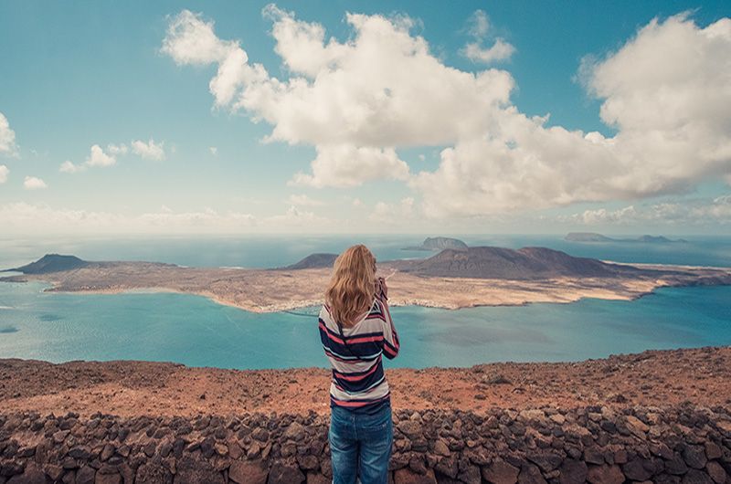 View from Mirador del Río looking out over La Graciosa, with volcanic cliffs and the deep blue sea as the main focus.