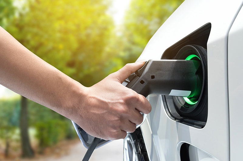 Person charging an electric vehicle at a charging point