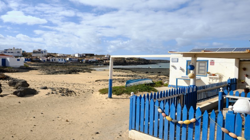 Majanicho, village de pêcheurs  à Fuerteventura avec des maisonnettes blanches et bleues le long de la côte volcanique, idéal pour une escapade tranquille.