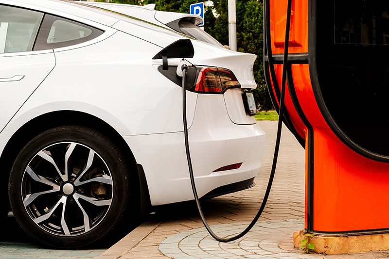 White coloured electric vehicle charging at a charging station